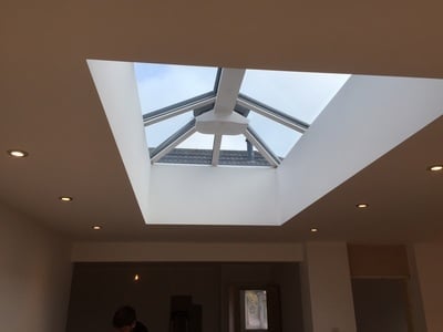 Modern skylight with geometric framing in a neutral-toned ceiling interior space